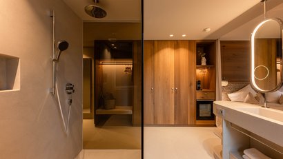 Modernes Hotelzimmer mit offener Dusche und Holzmöbeln