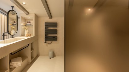 Modernes Badezimmer mit rundem Spiegel und Heizkörper an der Wand