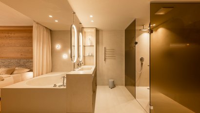Modern bathroom with bathtub, double sink, and shower with brown glass doors