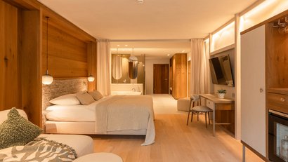 Hell eingerichtetes Hotelzimmer mit Bett, Badewanne und modernem Interieur