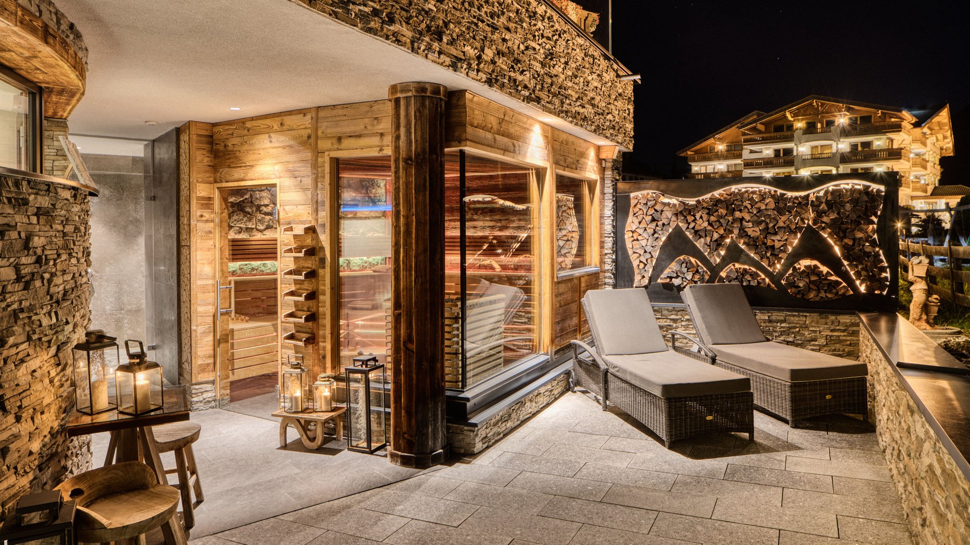 Gemütliche Terrasse mit Liegestühlen und beleuchtetem Holzdekor bei Nacht